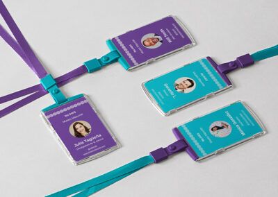 branding empresarial: Gafetes con identidad visual para el museo Mazunte. Hay gafetes color aqua con detalles morados y gafetes morados con detalles aqua. En todos se usa el símbolo del logo simulando una greca. La foto de las personas es circular.