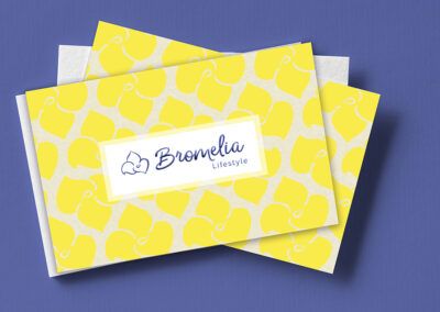 Personalidad de marca:: Tarjeta de presentación para Bromelia Lifestyle. La tarjeta tiene un mosaico con flores bromelia color amarillo y encima está el logotipo azul dentro de un rectángulo blanco.